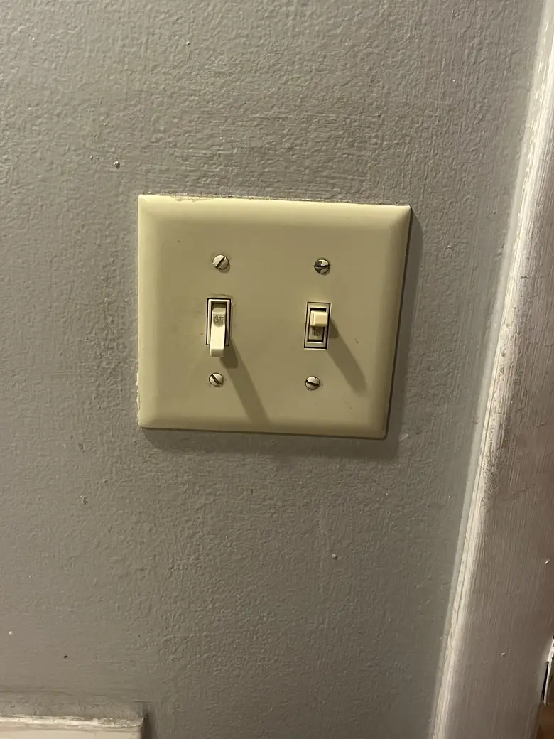 Before: dated almond toggle switches on the wall