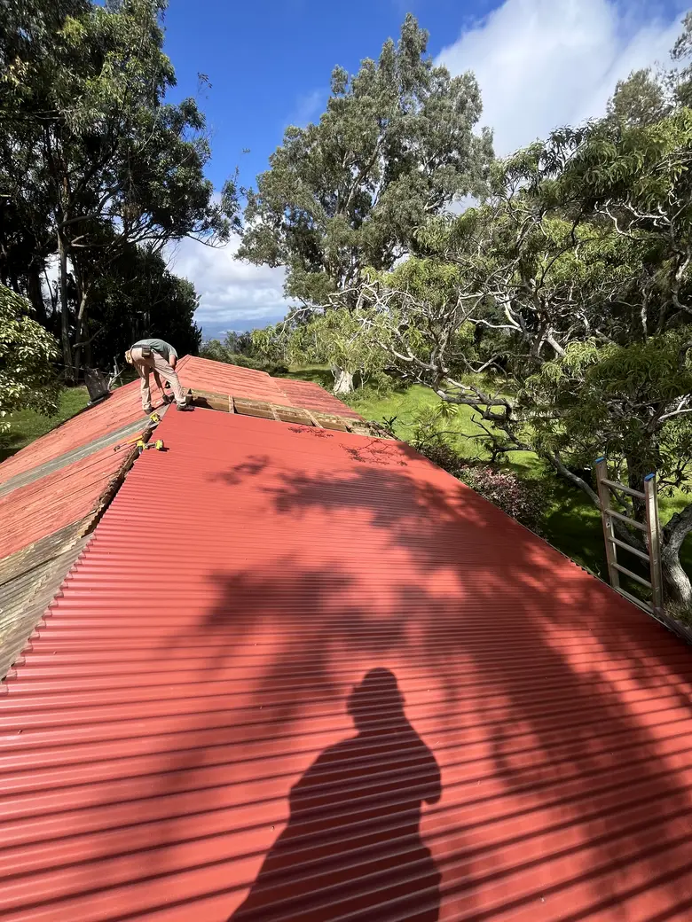 New red metal panels going down over the old frame